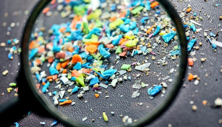 colorful plastic bits behind magnifying glass