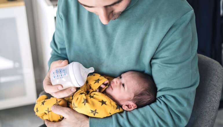 father gives new baby a bottle