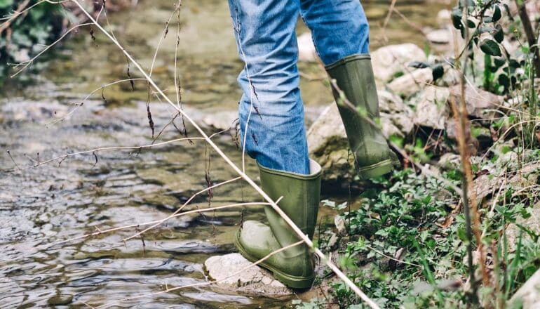 boots and legs of person at edge of stream