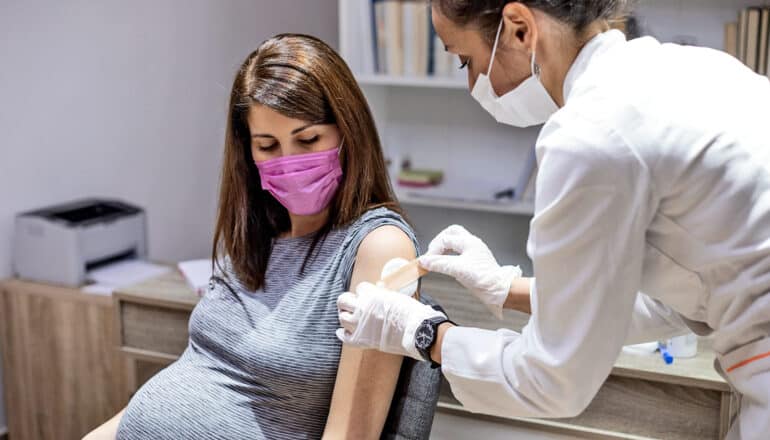 A woman gets a vaccine at a doctor's office.