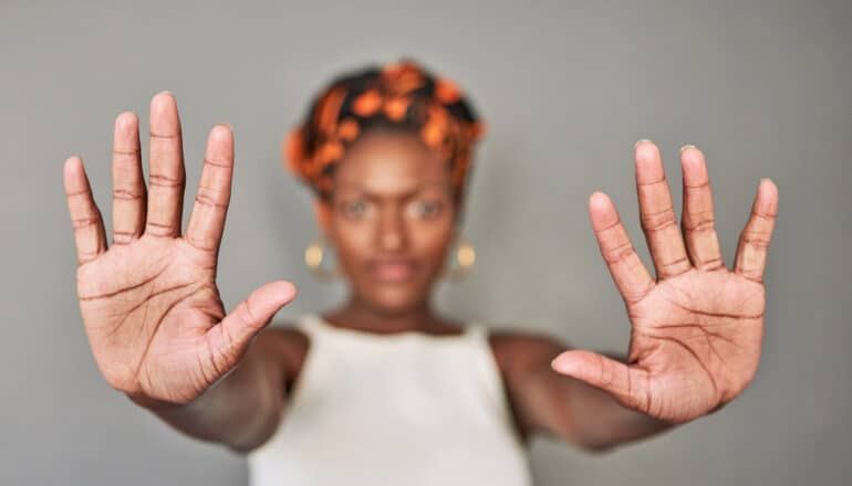 woman stands with hands out, showing all 10 fingers