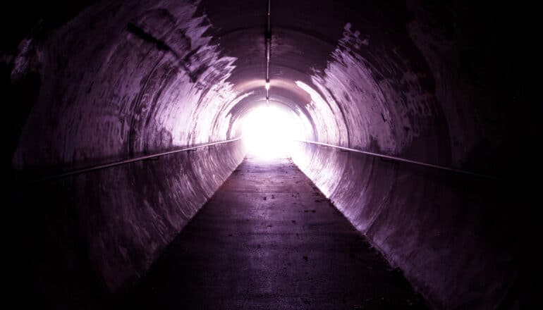 A long tunnel with a white light at the end.