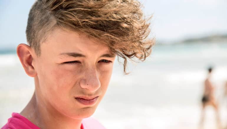 teen looks miserable on beach