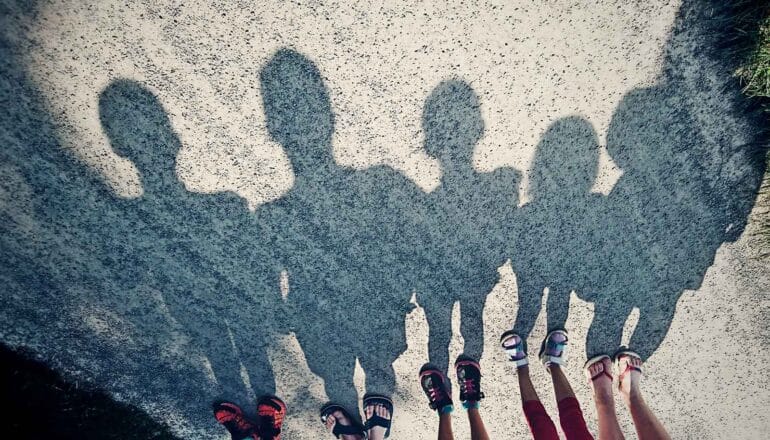 The shadows of several children standing in a row.