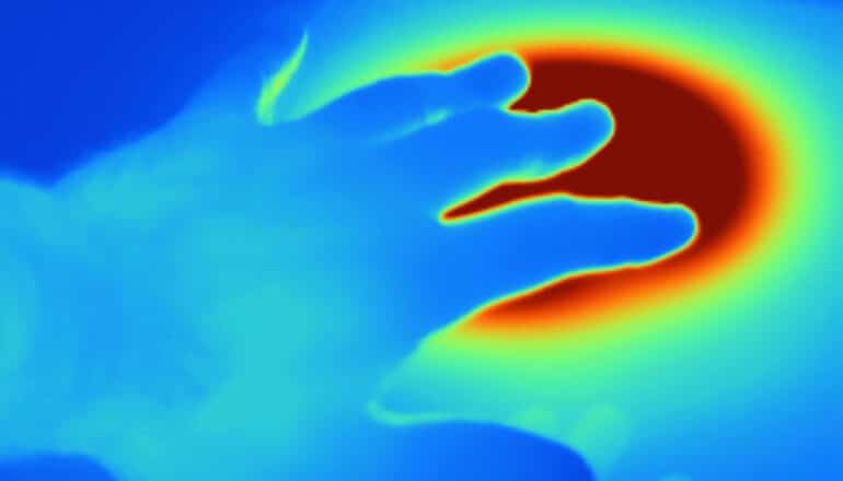 thermal image of hand near hot burner