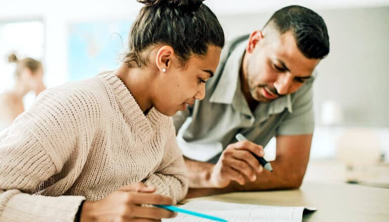 A teacher and student look over an assignment in the classroom.