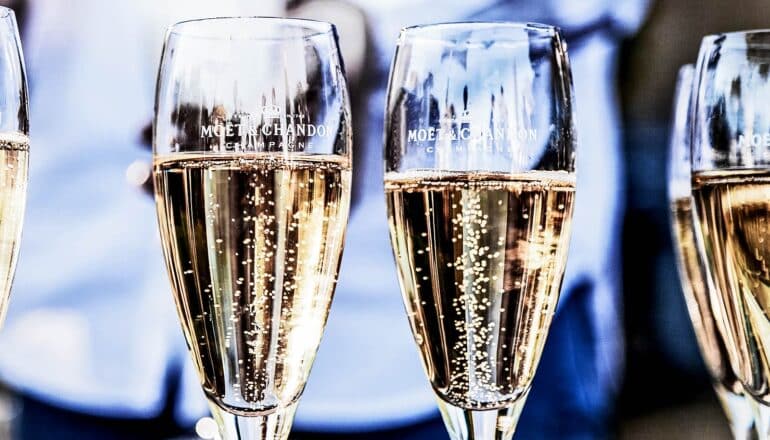 Flutes filled with champagne with bubbles floating straight up.