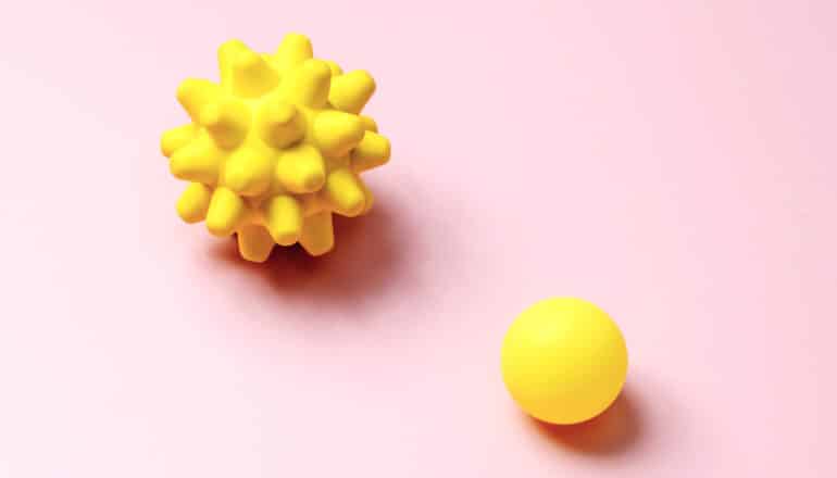 spiky and smooth yellow balls on pink background