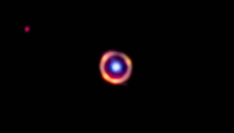 blue dot within orange ring on black