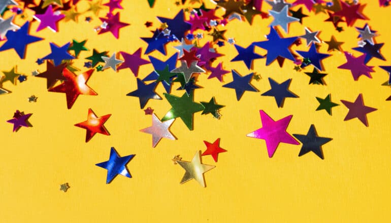 A yellow surface with colorful star stickers covering it.