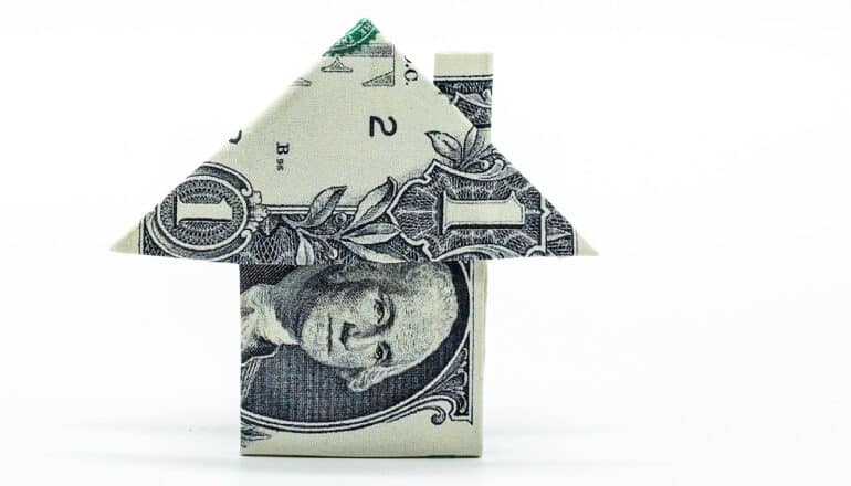 A dollar bill folded into the shape of a house.