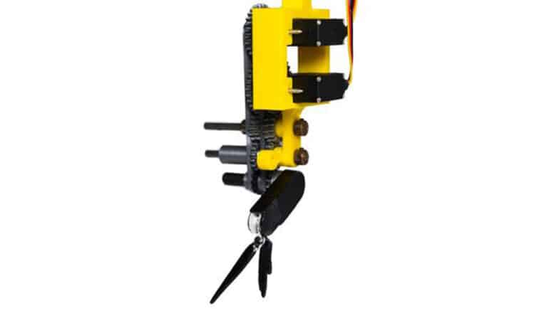 The small, black krill-inspired robot is attached to a larger yellow mechanism.