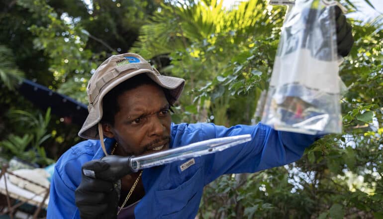 uniformed person holds baster and bag of water