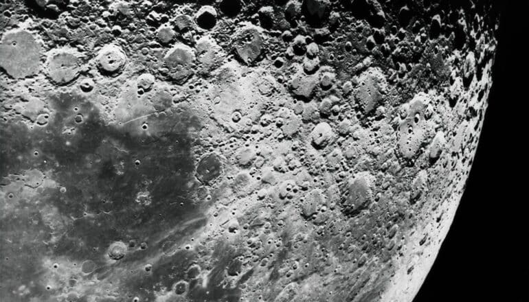 A close-up shot of the surface of the moon against the dark of space.