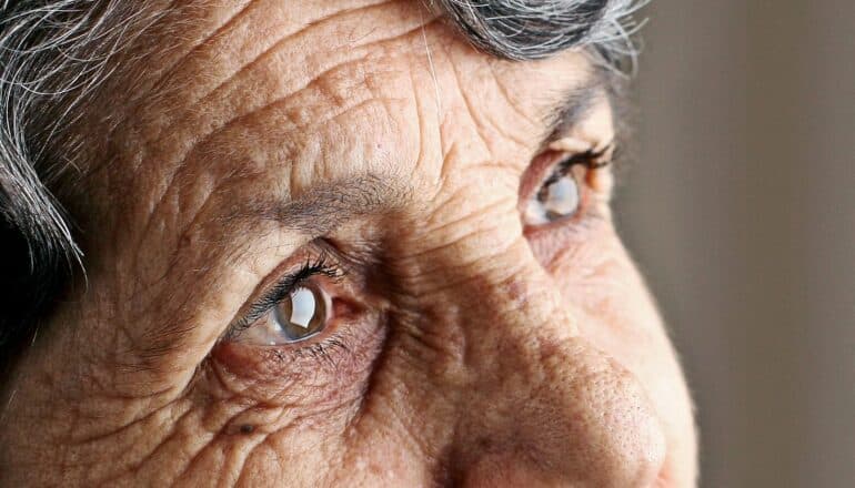 A close-up of an older woman's eyes as she looks into the distance.