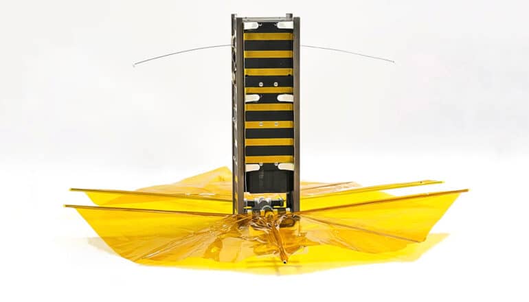 The satellite has a main rectangular body with a yellow, cellophane-like sail at its bottom.