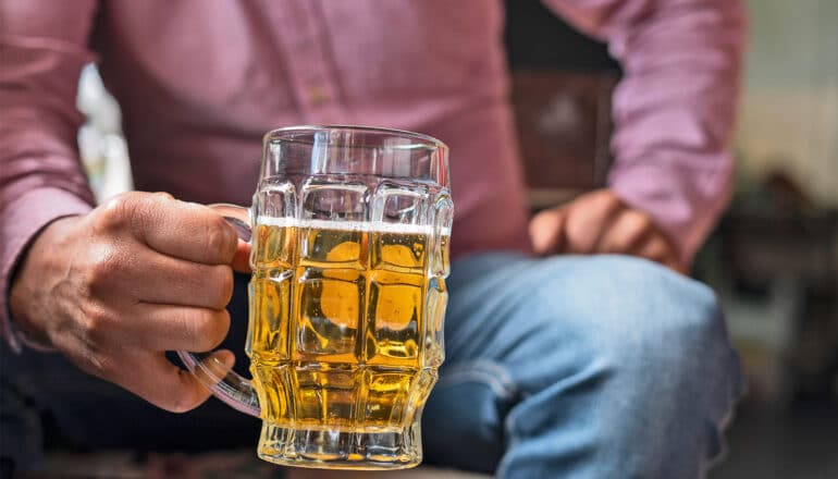 A man holds a stein of beer.