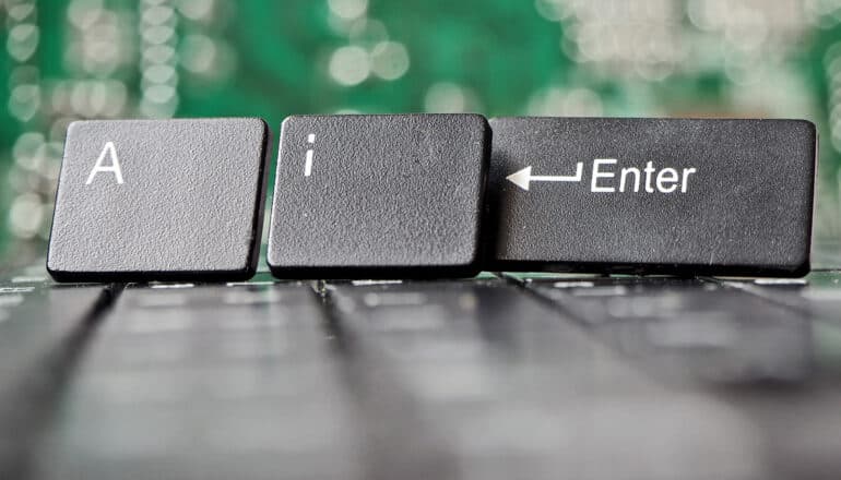 An "a" and "i" keyboard key standing up next to an "enter" key.