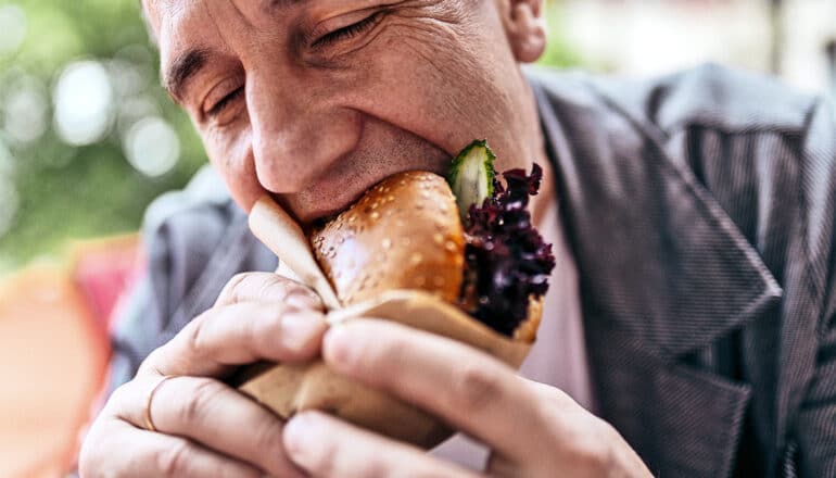 A man eats a hamburger.