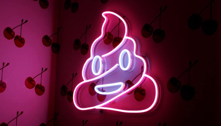 neon poop emoji on wall