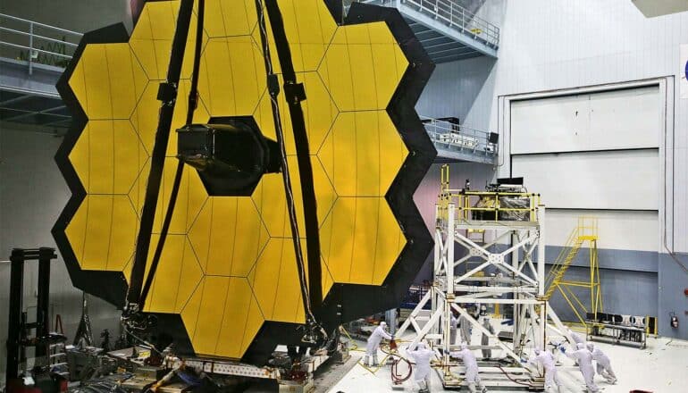 The James Webb Space Telescope under construction with its mirrors arranged like a honeycomb pattern.