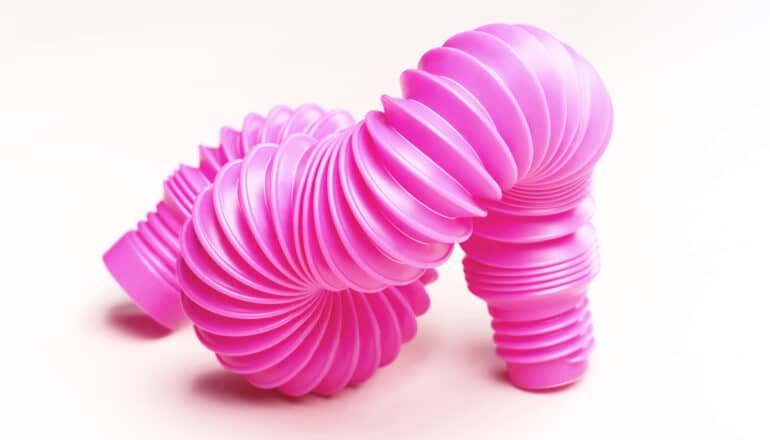 A twisty pink tube from a child's toy on a white background.