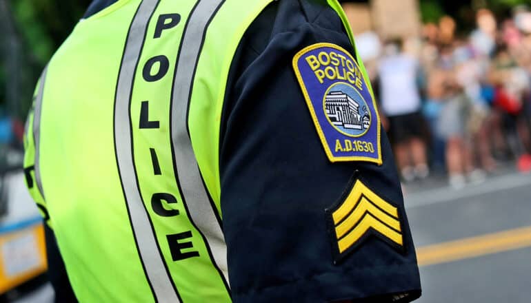 close-up of police officer's neon vest and patches on shirt sleeve