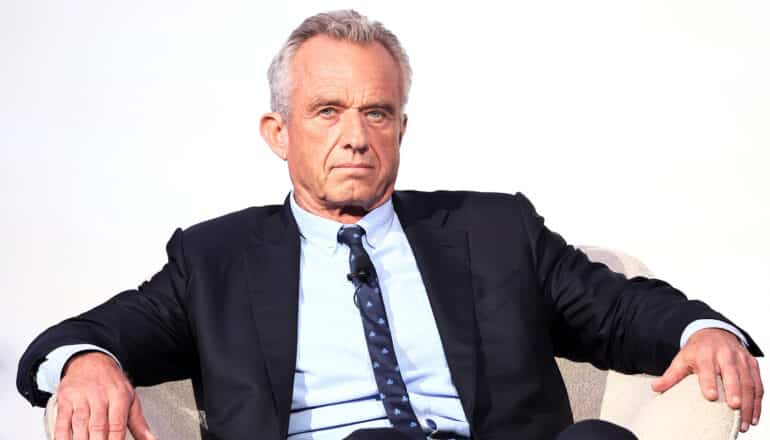 serious RFK Jr sits in chair