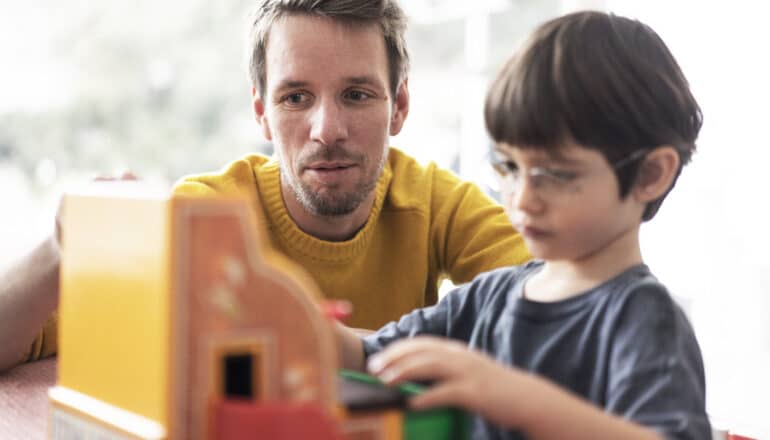 adult and child play with toy cash register