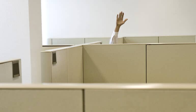 raised hand over wall of cubicle