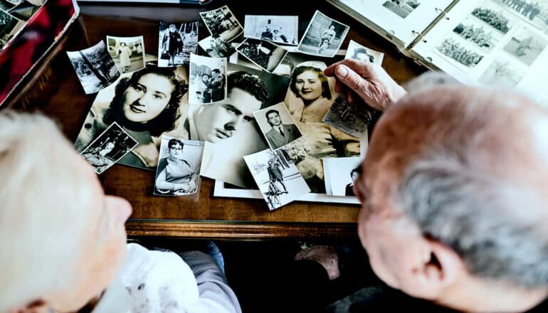 Two people look at old photographs together.