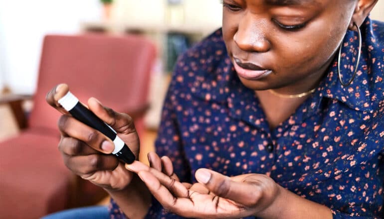 A young woman tests her blood sugar.