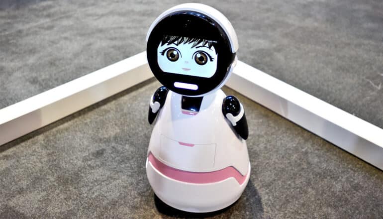 A companion robot with a screen showing a cartoon-like face.