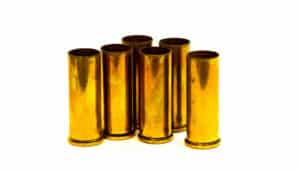 six brass shell casings on white