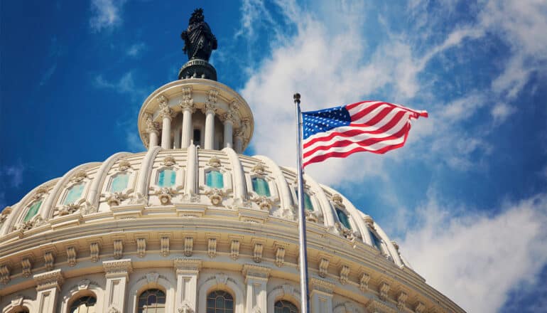 A view of the capitol building's dome and an American flag.