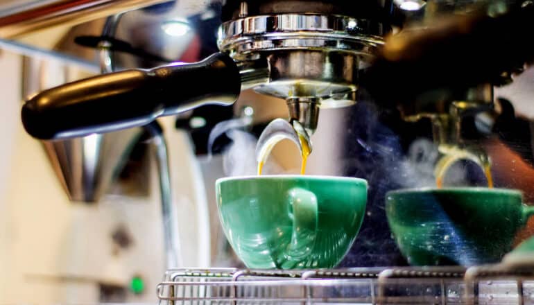 espresso machine pours into green mug