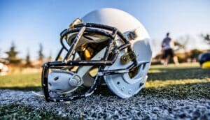 A football helmet sits on a grassy field.