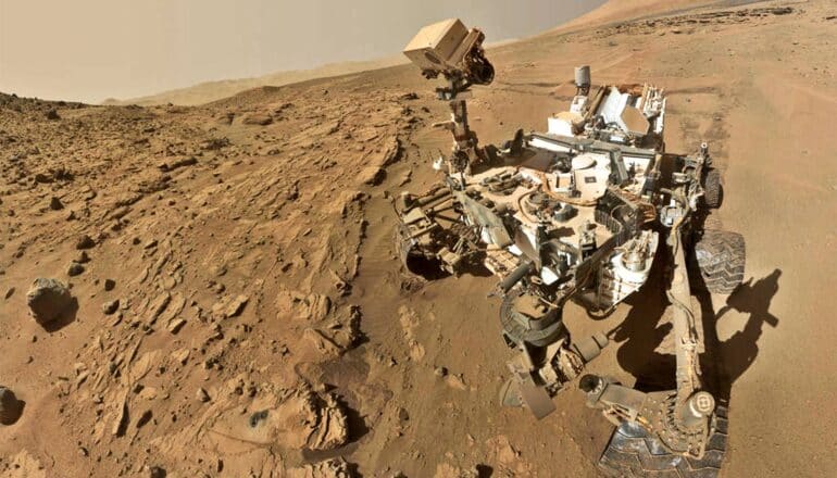 A "self-portrait" of the Curiosity rover on Mars shows the rover and the vast, barren landscape of the planet behind it.