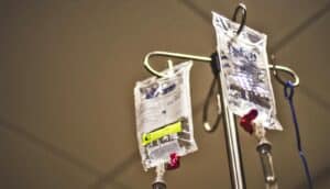 IV drip bags hanging on a rack to deliver chemotherapy.