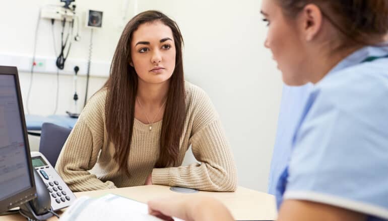 A school nurse speaks with a student.