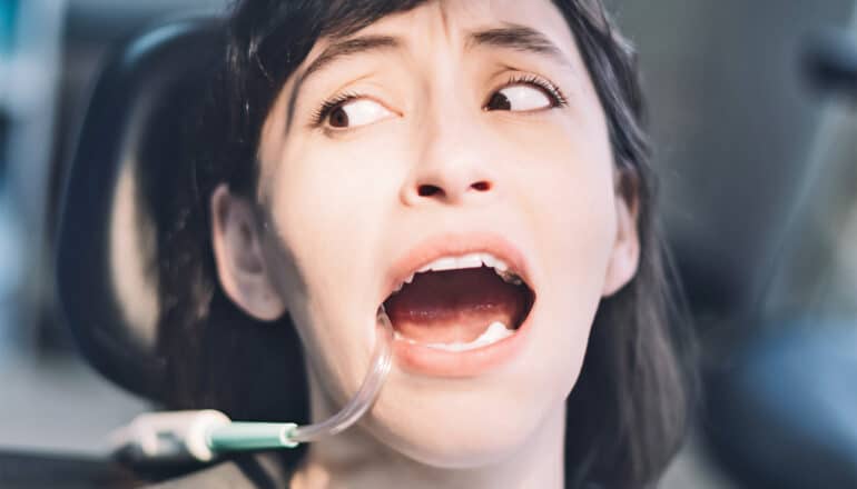 A woman looks scared while at the dentist.