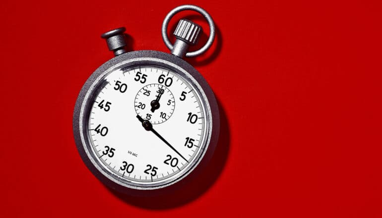 A stopwatch on a red background.