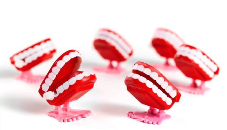 A group of wind-up chattering teeth toys on a white background.