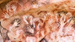 Human hands stenciled on a cave wall.