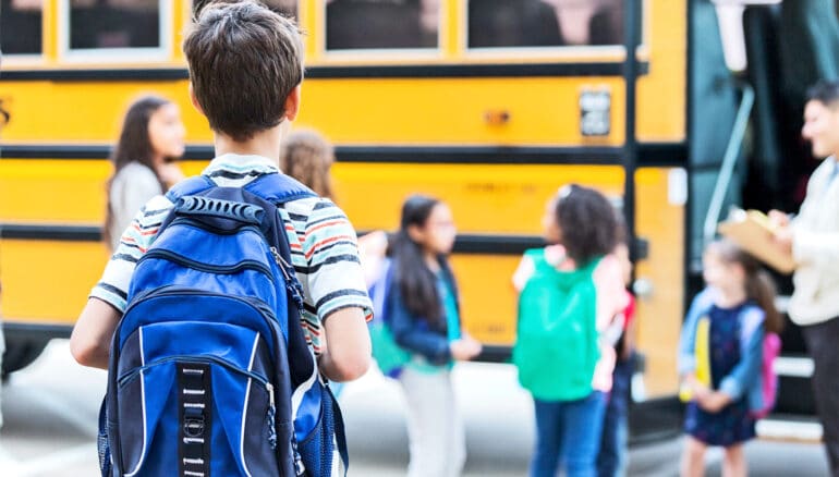 Young students get into a school bus.