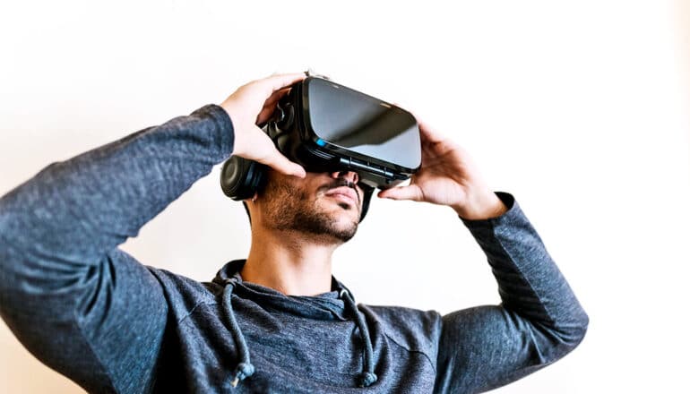 A man puts on a virtual reality headset.