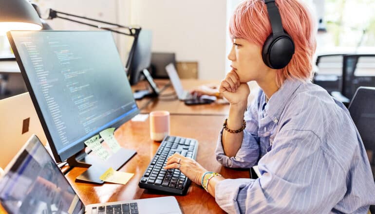 A woman works at a computer in an office.