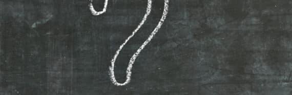 A question mark drawn on a blackboard in white chalk.