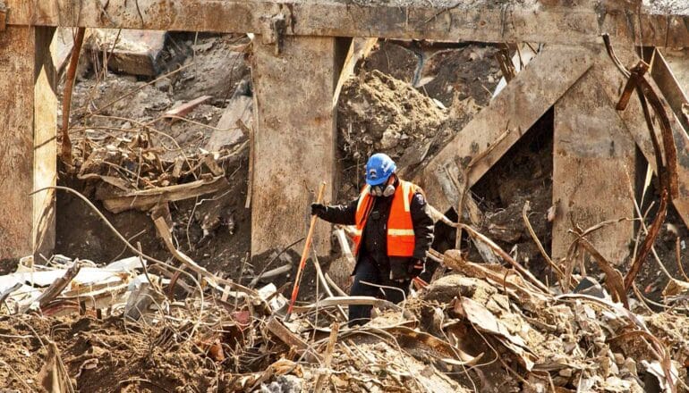 A first responder walks through debris and wreckage from the World Trade Center.