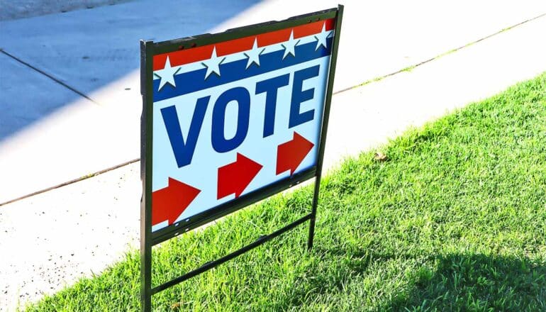 A sign with the word "Vote" on it points voters to a polling place.